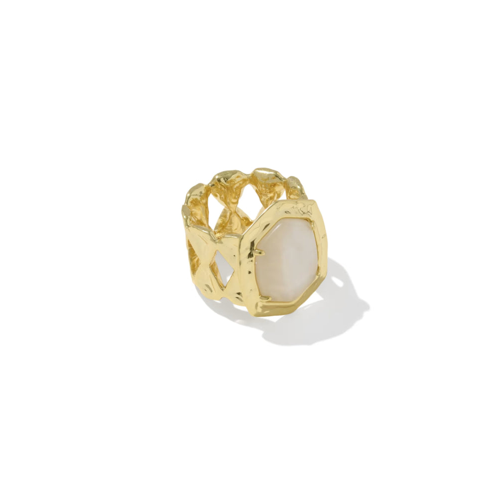 A gold ring with a large, faceted white stone, photographed on a clean white background with a soft shadow.