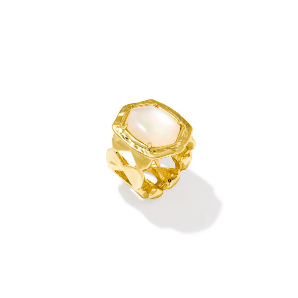 A gold ring featuring a large, irregular hexagonal white mother-of-pearl cabochon gemstone, set against a clean white background with a soft shadow.