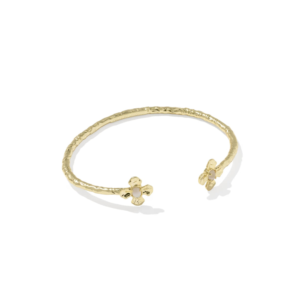 A textured gold open cuff bracelet with two small bow-shaped charms, each adorned with a tiny clear stone, shown on a white background.