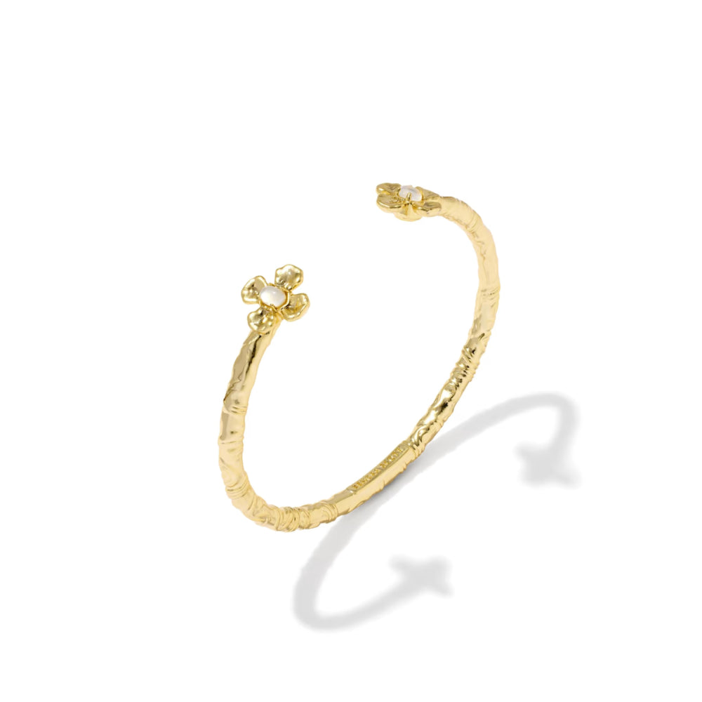 A textured gold open cuff bracelet with a small flower-shaped clasp on one end, shown on a clean white background with a soft shadow.