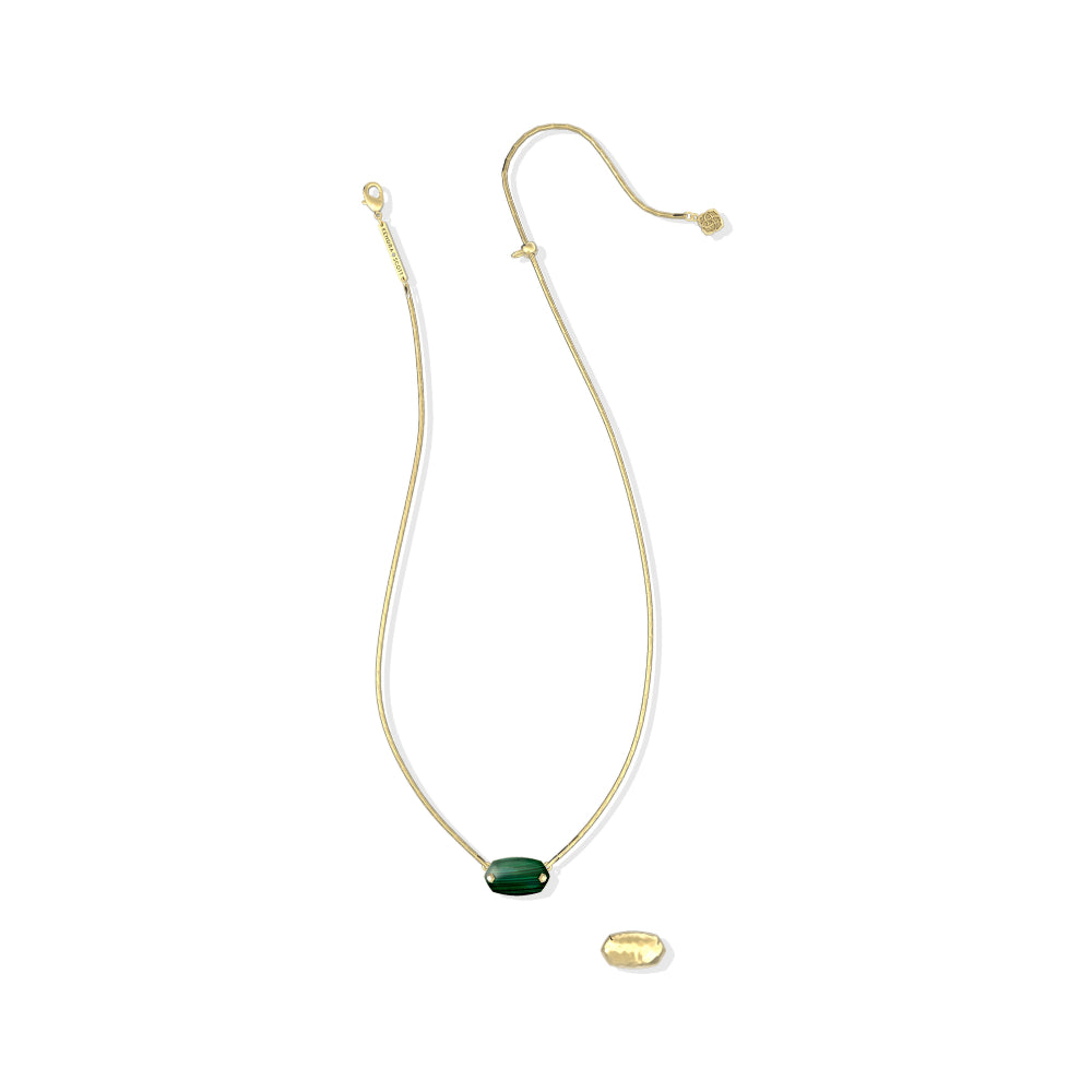 A delicate gold chain necklace featuring a small oval green stone pendant, displayed on a clean white background with a small gold tag below it.