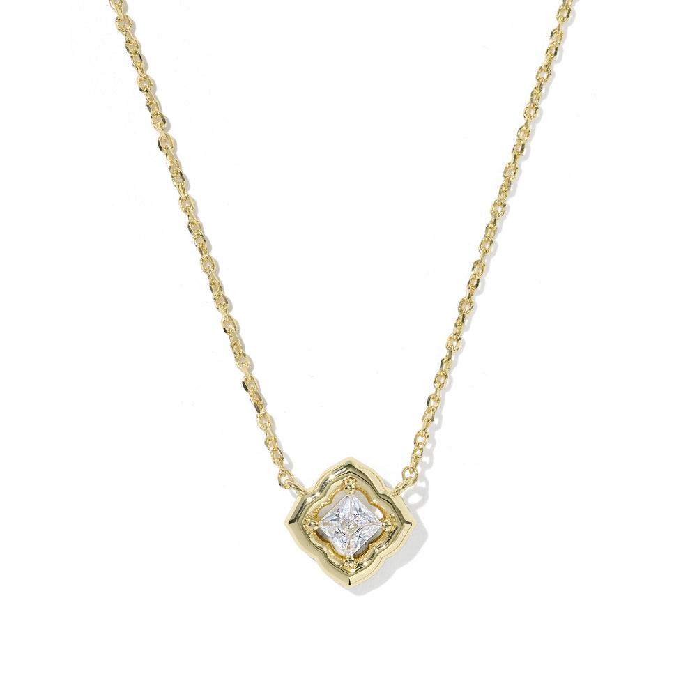 A delicate yellow gold chain necklace with a small geometric pendant featuring a clear central gemstone, shown on a plain white background.