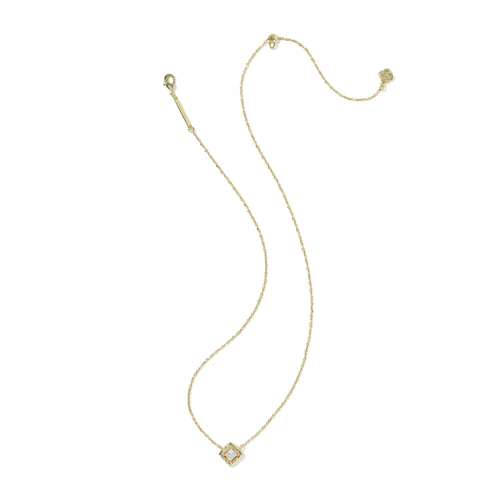 A delicate gold chain necklace featuring a small square pendant with a clear gemstone, displayed on a solid white background.