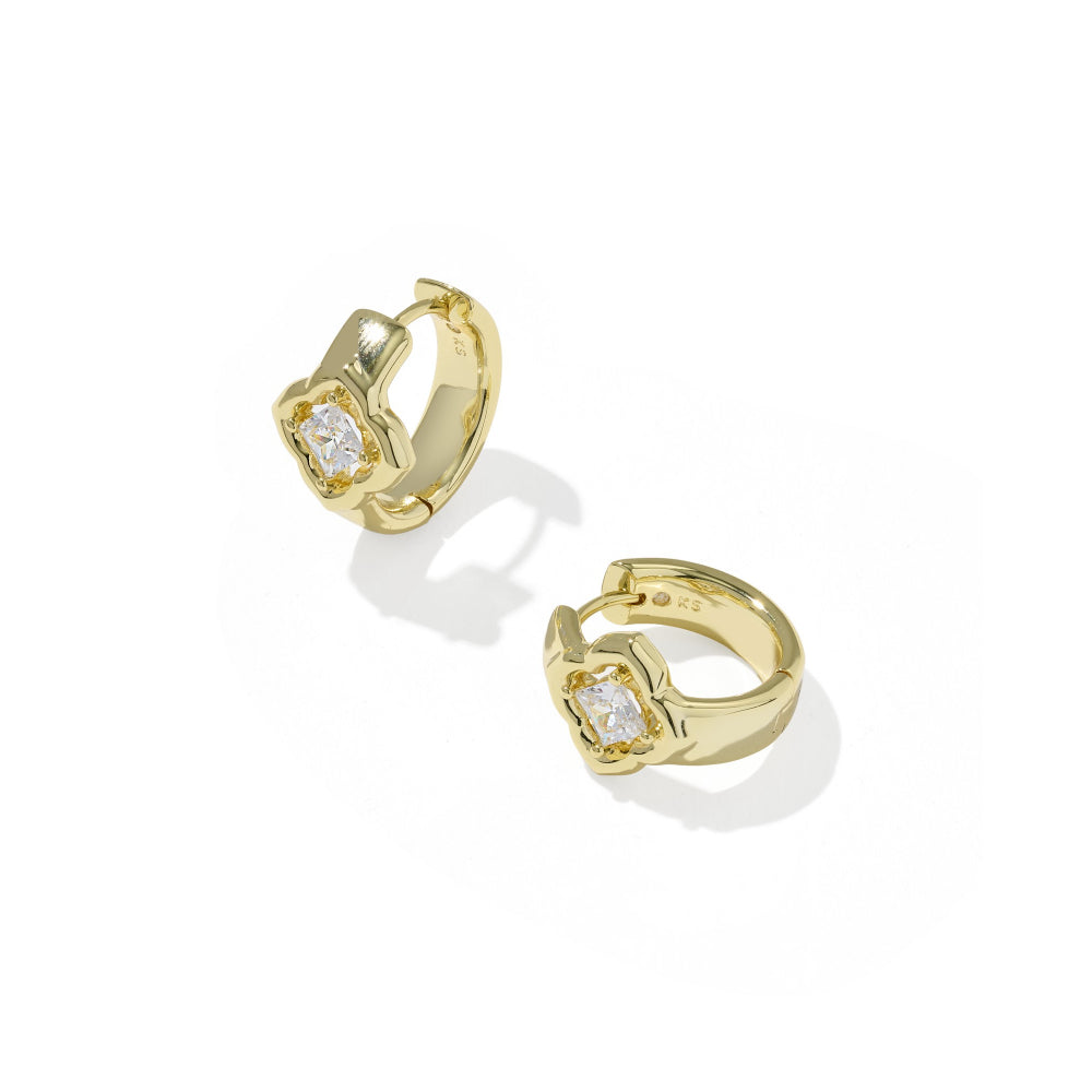 A pair of gold huggie hoop earrings with a central bezel-set clear gemstone, displayed on a clean white background with soft shadows.