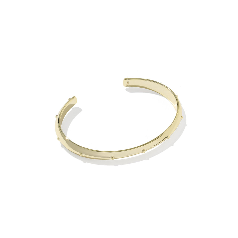 A polished gold open cuff bracelet with small evenly spaced studs, shown on a clean white background with a soft shadow.