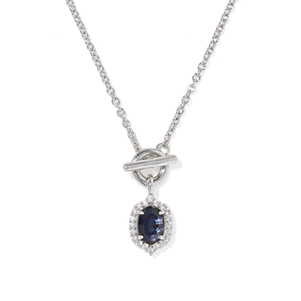A silver-tone chain necklace with a toggle clasp and a teardrop-shaped dark blue sapphire pendant surrounded by a halo of small clear stones, shown on a plain white background.