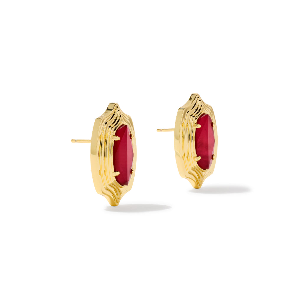 A pair of gold post earrings with oval red gemstones, shown from the side on a clean white background.