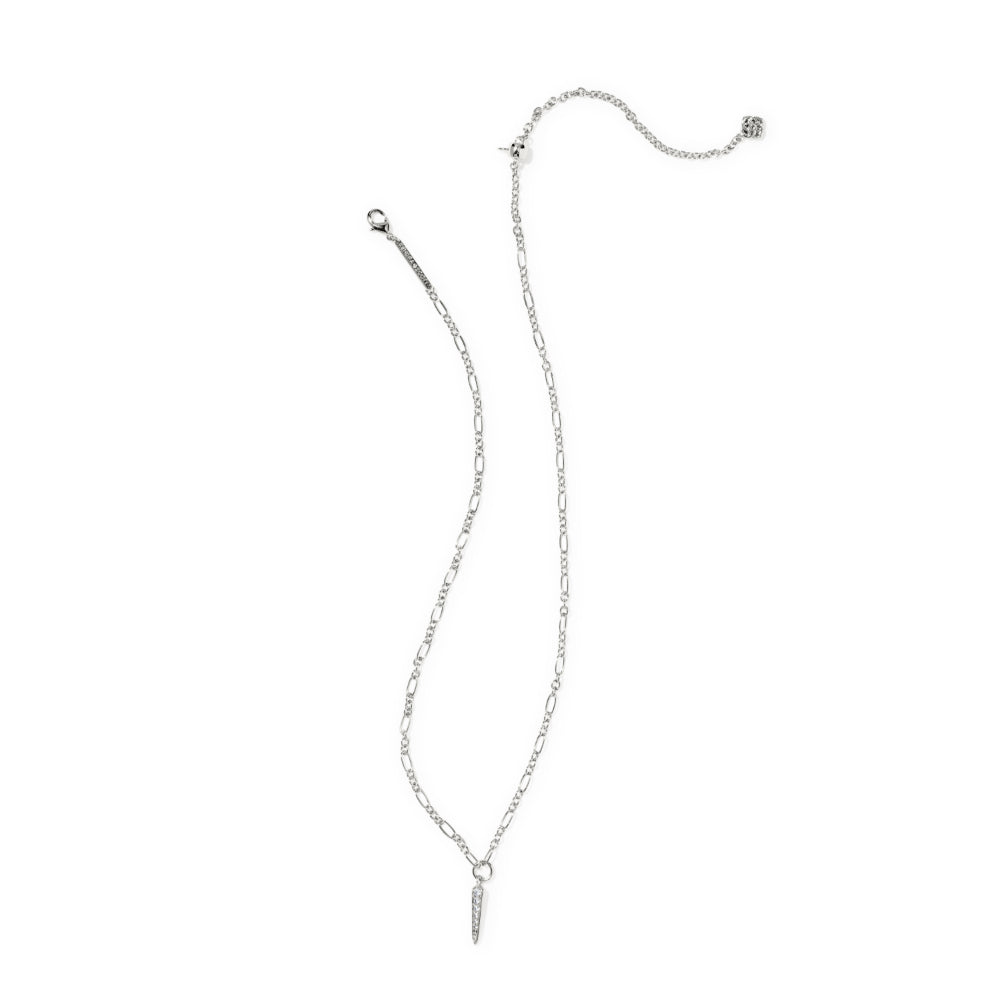 A delicate silver chain necklace with a small, pointed diamond-like pendant, displayed on a clean white background.