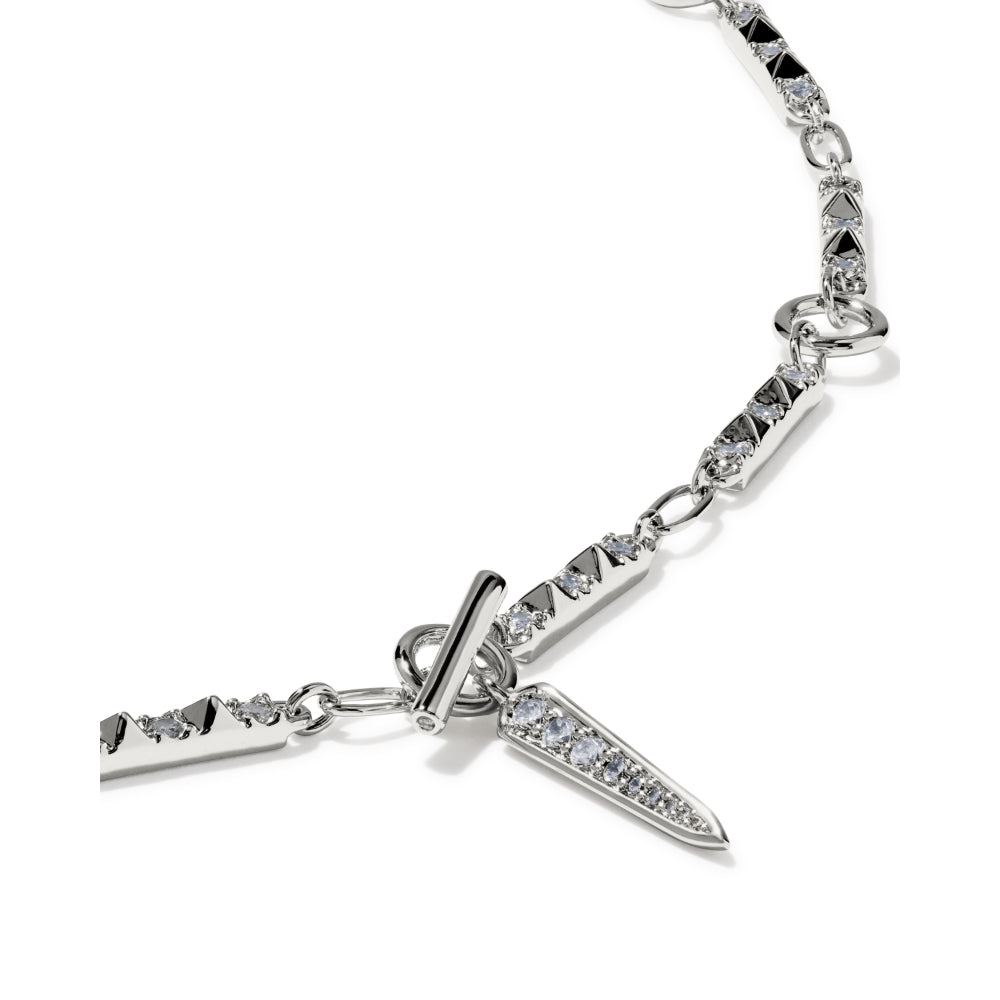 A silver-toned chain bracelet featuring a dagger pendant and matching dagger-shaped links, embellished with clear pavé stones, shown on a white background.