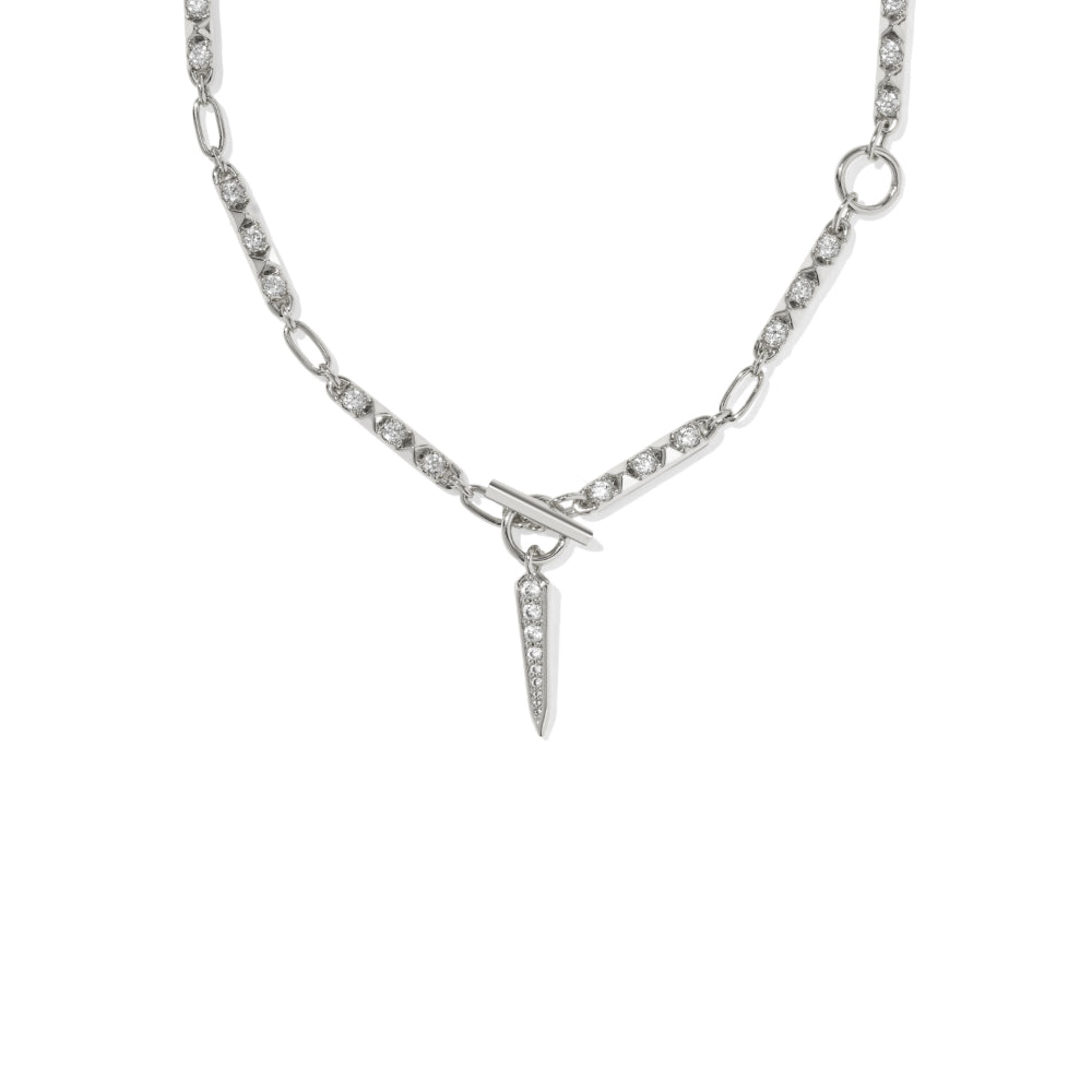 A silver-toned chain necklace featuring a central spike charm paved with small clear stones, displayed against a solid white background.