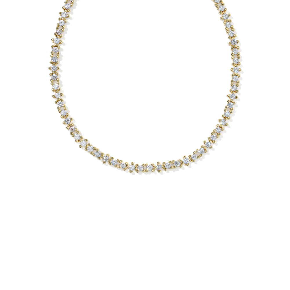 A delicate gold tennis necklace adorned with small round-cut clear gemstones, displayed against a solid white background.