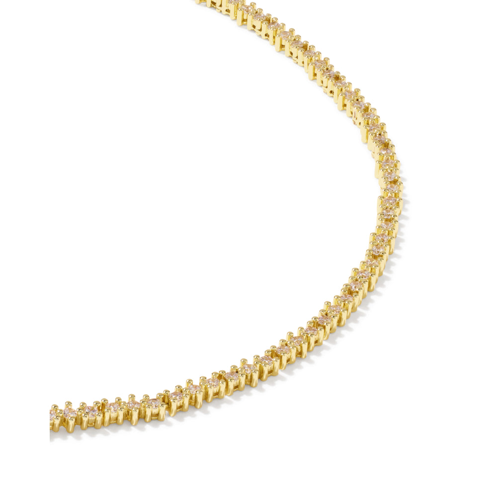 A yellow gold tennis necklace with small clear stones, photographed on a clean white background.