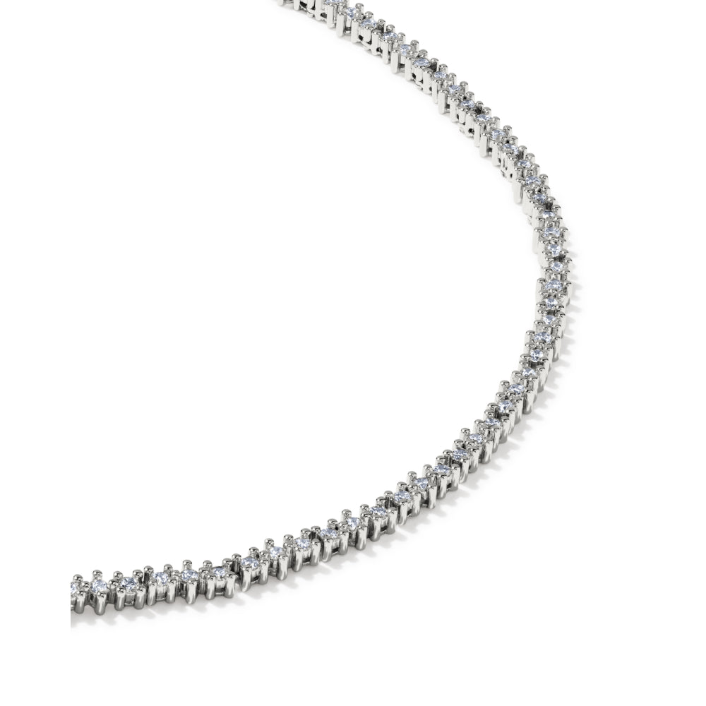 A curved silver tennis necklace featuring small clear stones in prong settings, photographed on a clean white background.