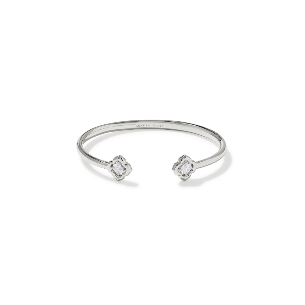 A silver open cuff bangle bracelet with two small clear gemstones at the ends, shown on a plain white background.