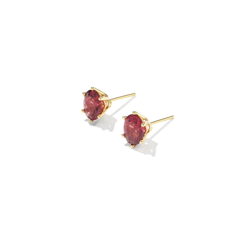 Gold earrings with red gemstones on a white background