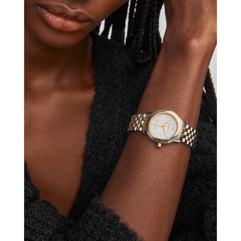 Gold watch on a wrist with a blurred background