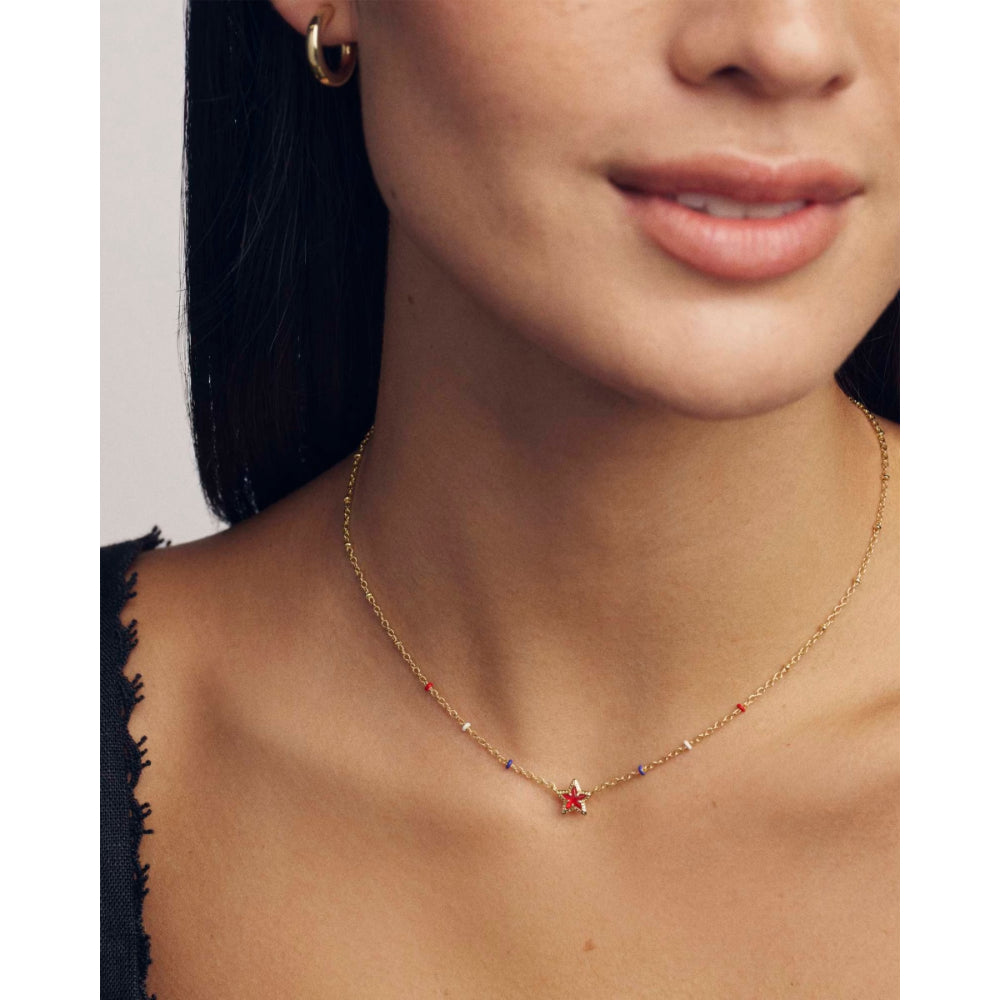 Close-up of a woman wearing a gold necklace with a star pendant.