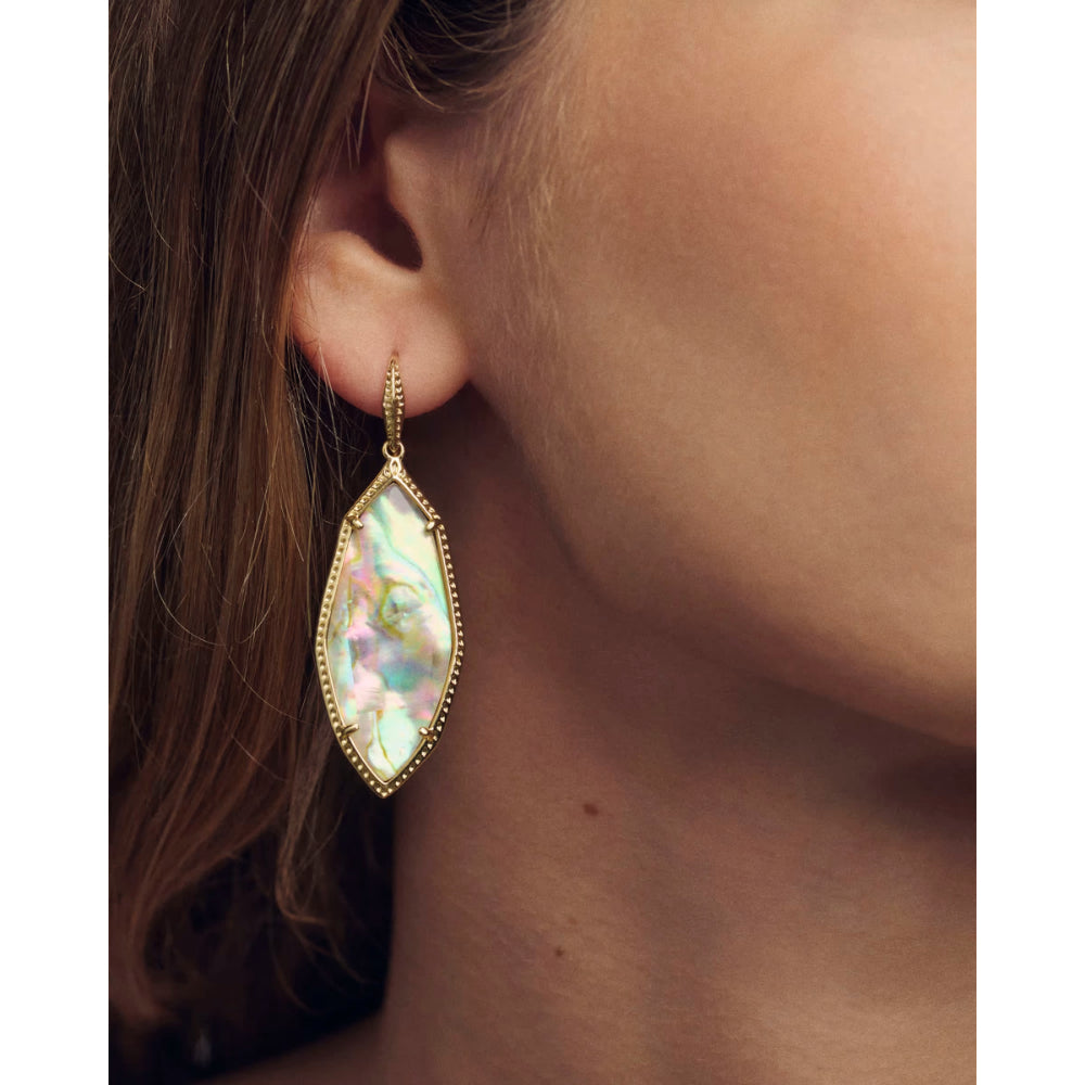 Close-up of an earring with a colorful gemstone on a person's ear.