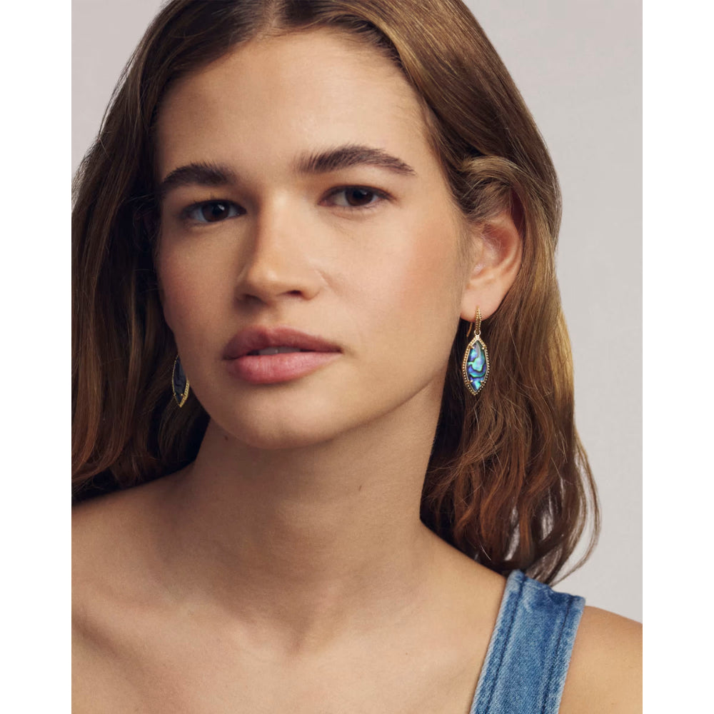 Woman wearing earrings with a neutral background