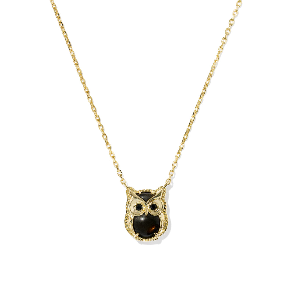 Gold owl pendant necklace with a dark brown owl face and large white eyes, on a delicate gold chain against a white background.