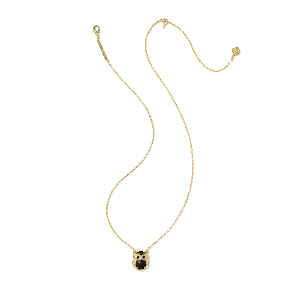 A delicate gold chain necklace featuring an owl pendant with a black center and small gold details, displayed on a clean white background.