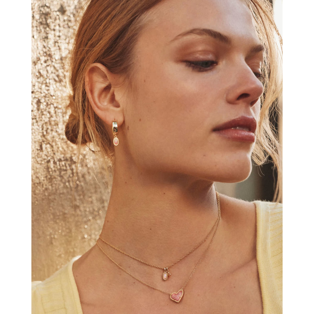 Close-up of a woman wearing gold necklaces and earrings with a blurred background