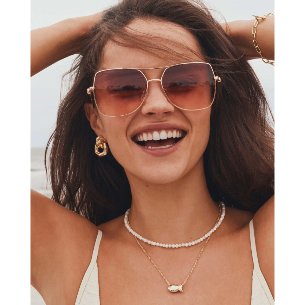 Woman wearing sunglasses and jewelry with a blurred background
