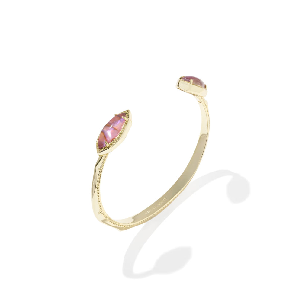 Gold open cuff bracelet with pink gemstones on a white background