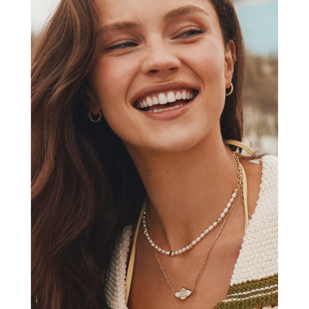 Woman wearing a necklace with a blurred natural background