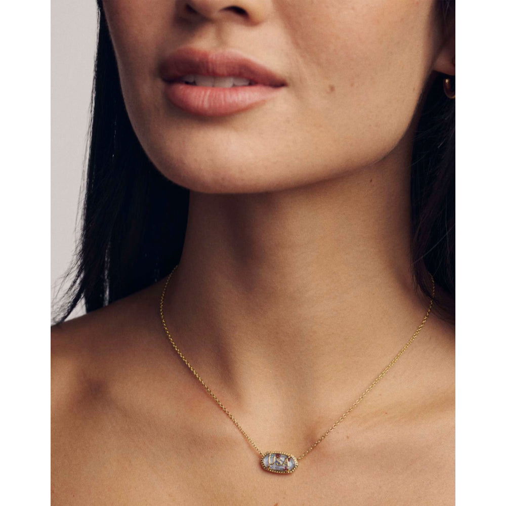 Close-up of a woman wearing a gold necklace with a pendant.