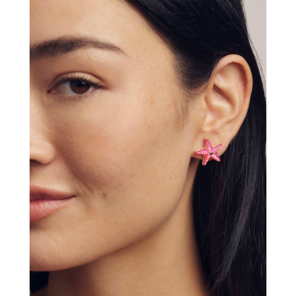 Close-up of a woman wearing pink star-shaped earrings.
