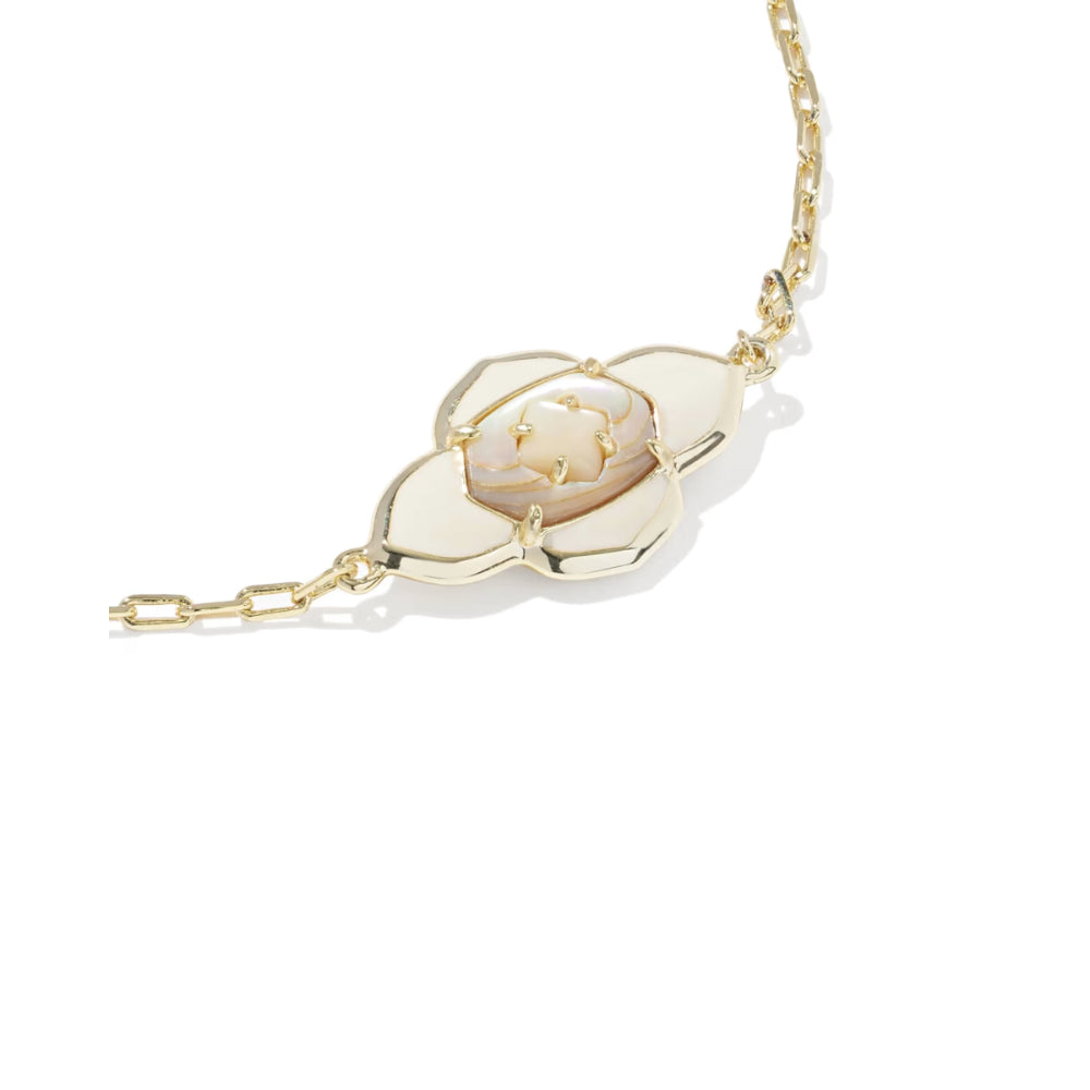Gold bracelet with a white pendant on a white background