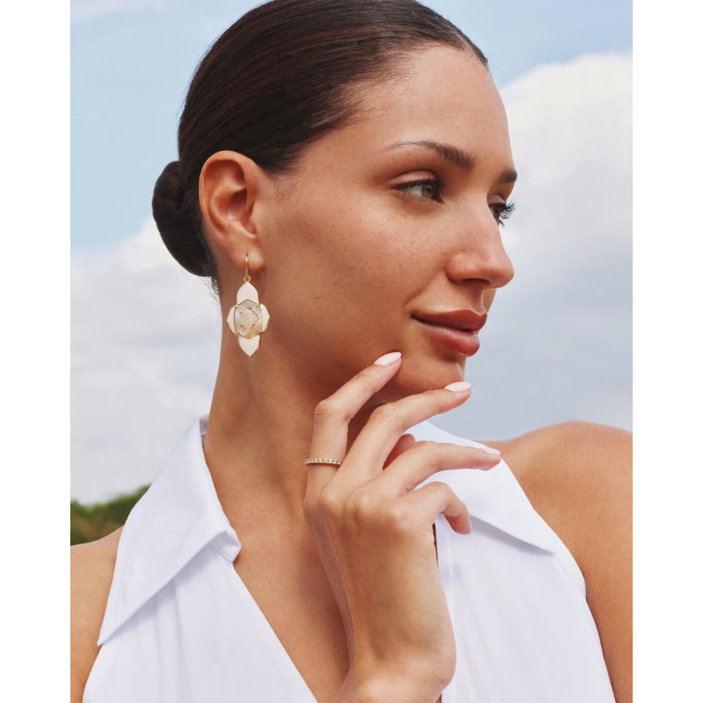 Woman wearing a white sleeveless top with a blurred background