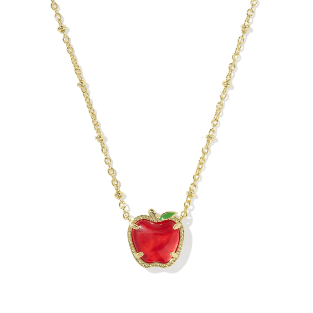 A gold chain necklace featuring an apple-shaped pendant with a vibrant red enamel body, a small green leaf accent, and a textured gold border, shown against a plain white background.
