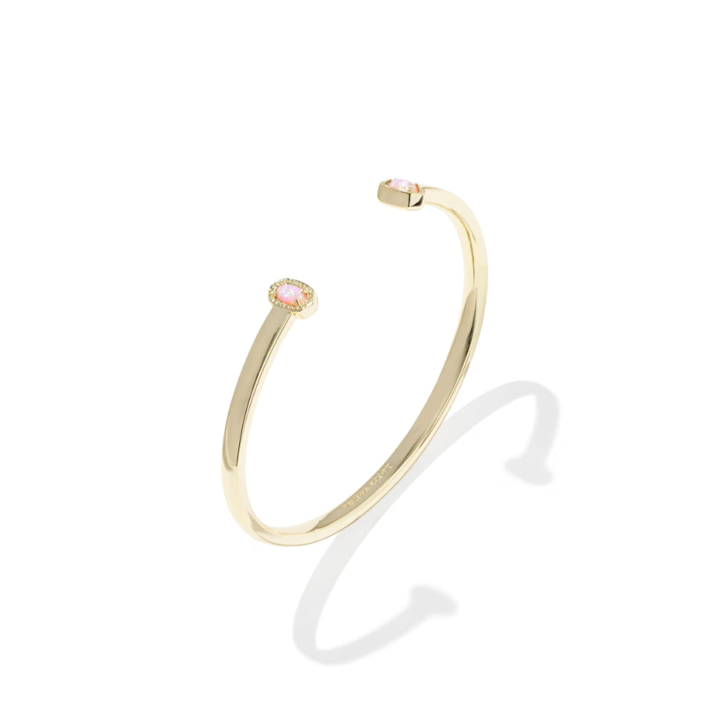 Gold bracelet with a pink gemstone on a white background