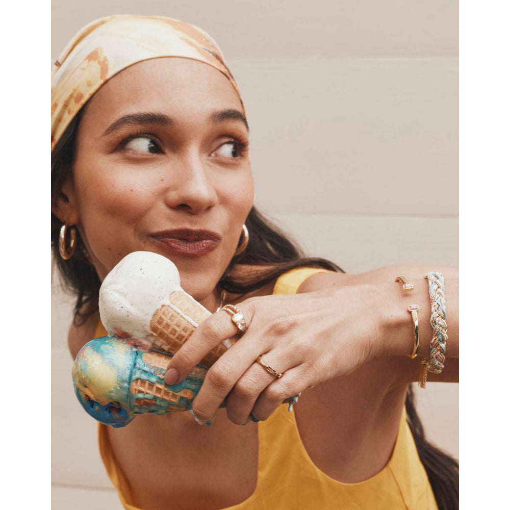 Woman holding a small ice cream cone-shaped object with a world map design.