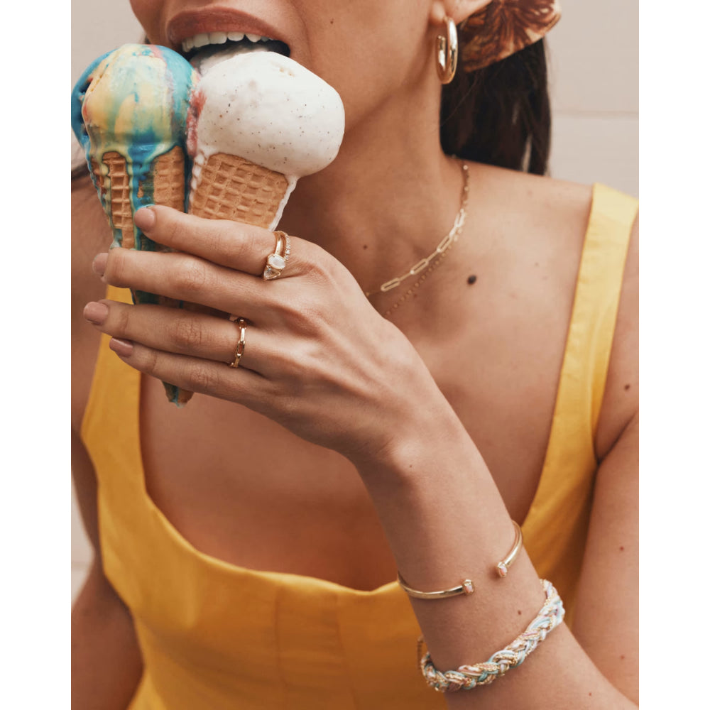 Person holding a colorful ice cream cone with a neutral background