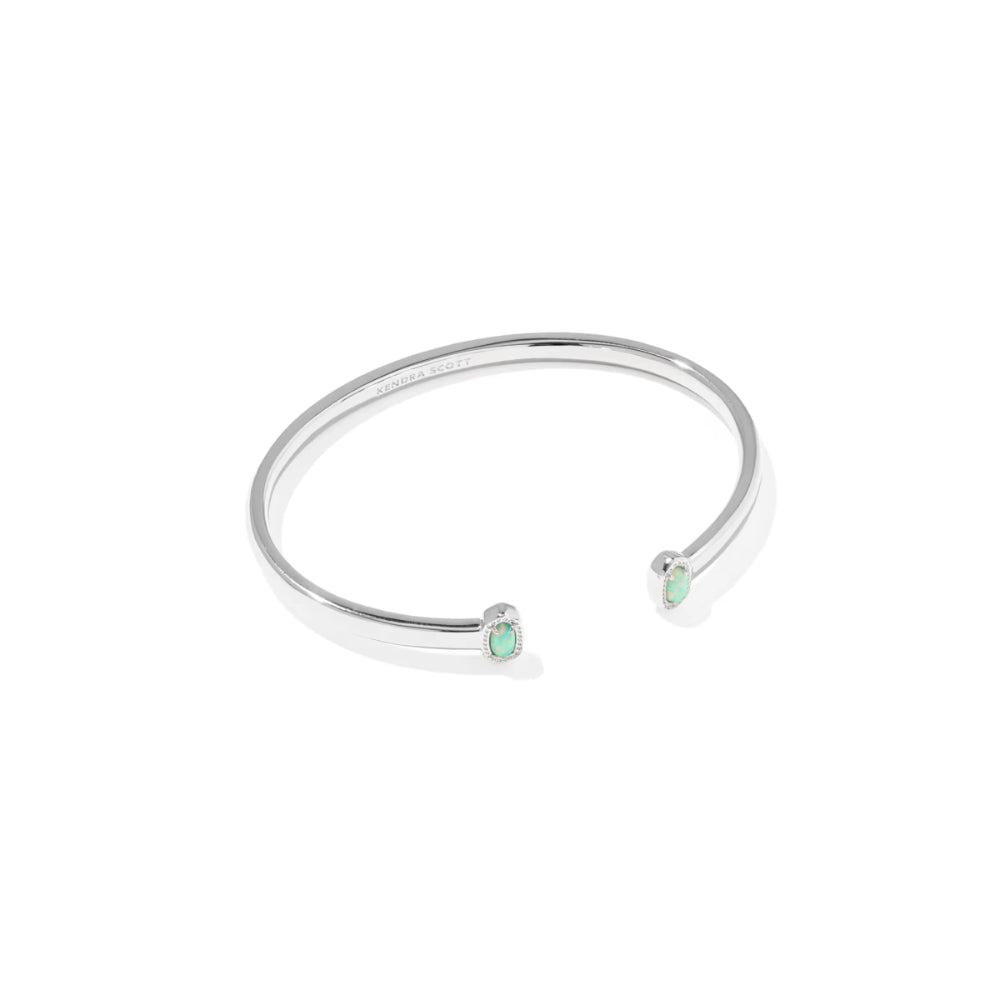 Silver bracelet with green gemstones on a white background