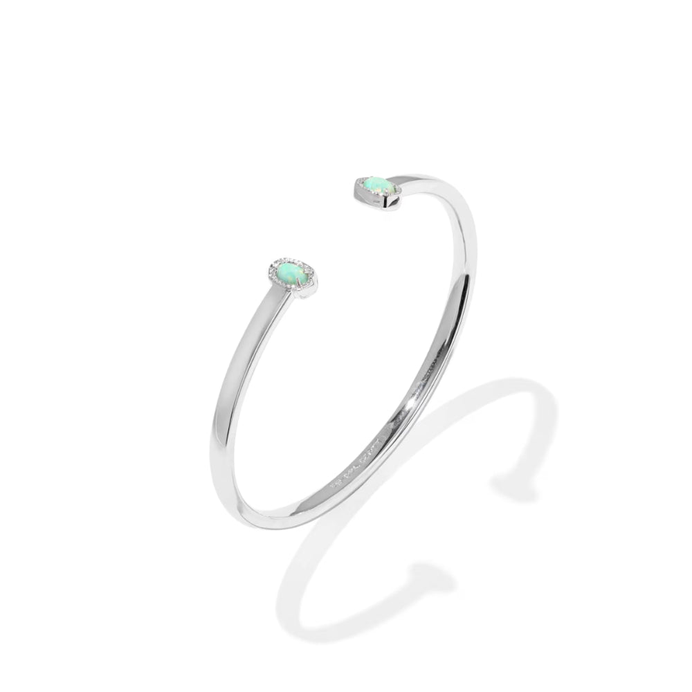 Silver bangle with a small gemstone on a white background