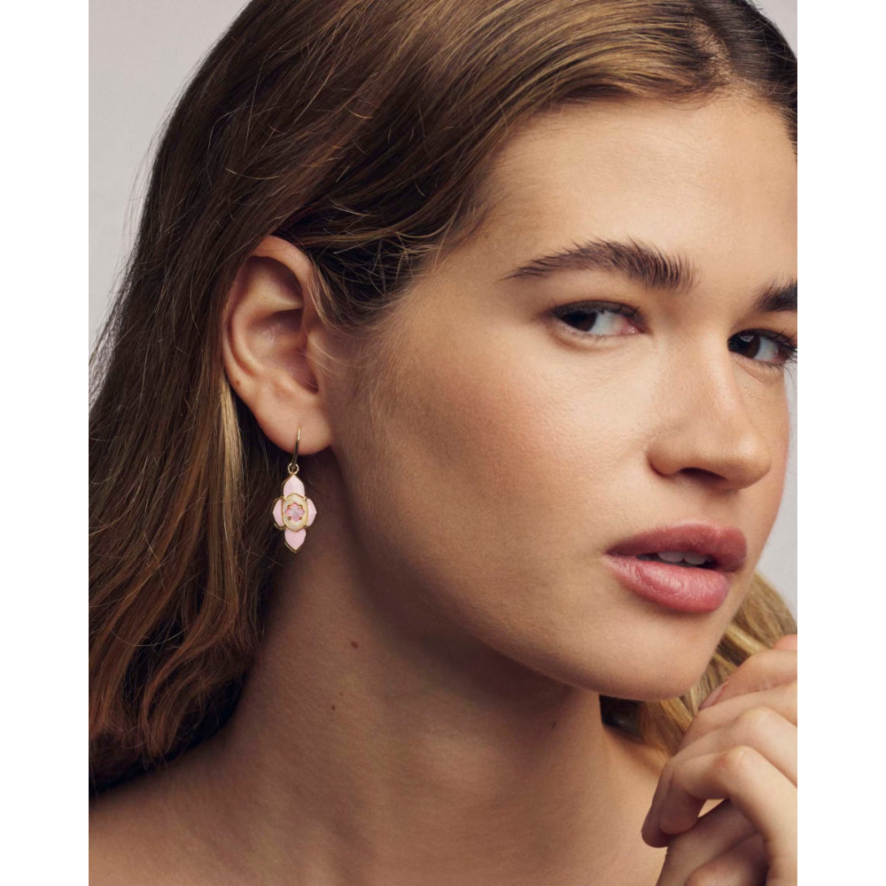 Close-up of a woman wearing a delicate earring with a neutral background