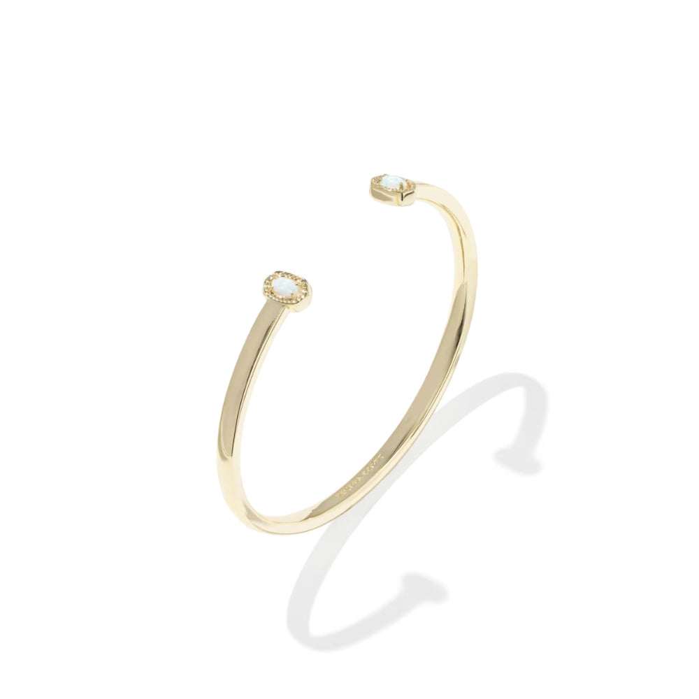 Gold bracelet with a small gemstone on a white background
