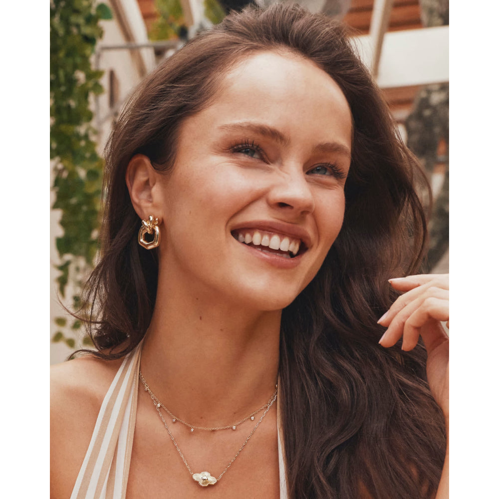 Woman with long brown hair smiling outdoors