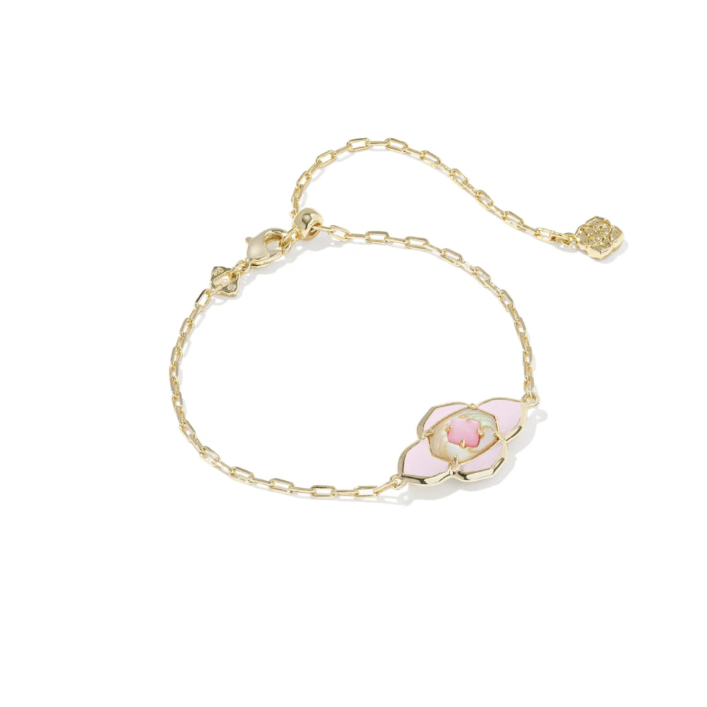 Gold bracelet with a pink flower charm on a white background
