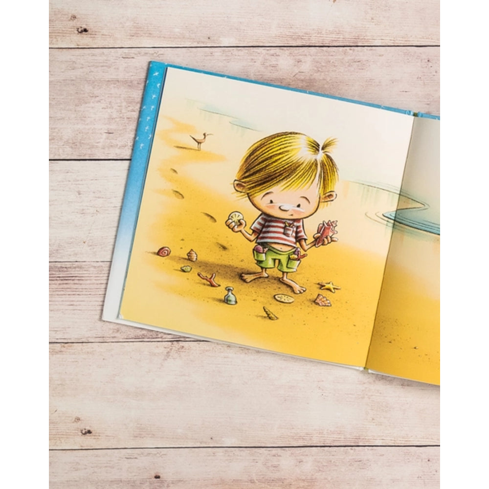 Illustrated book open to a page with a child on a beach