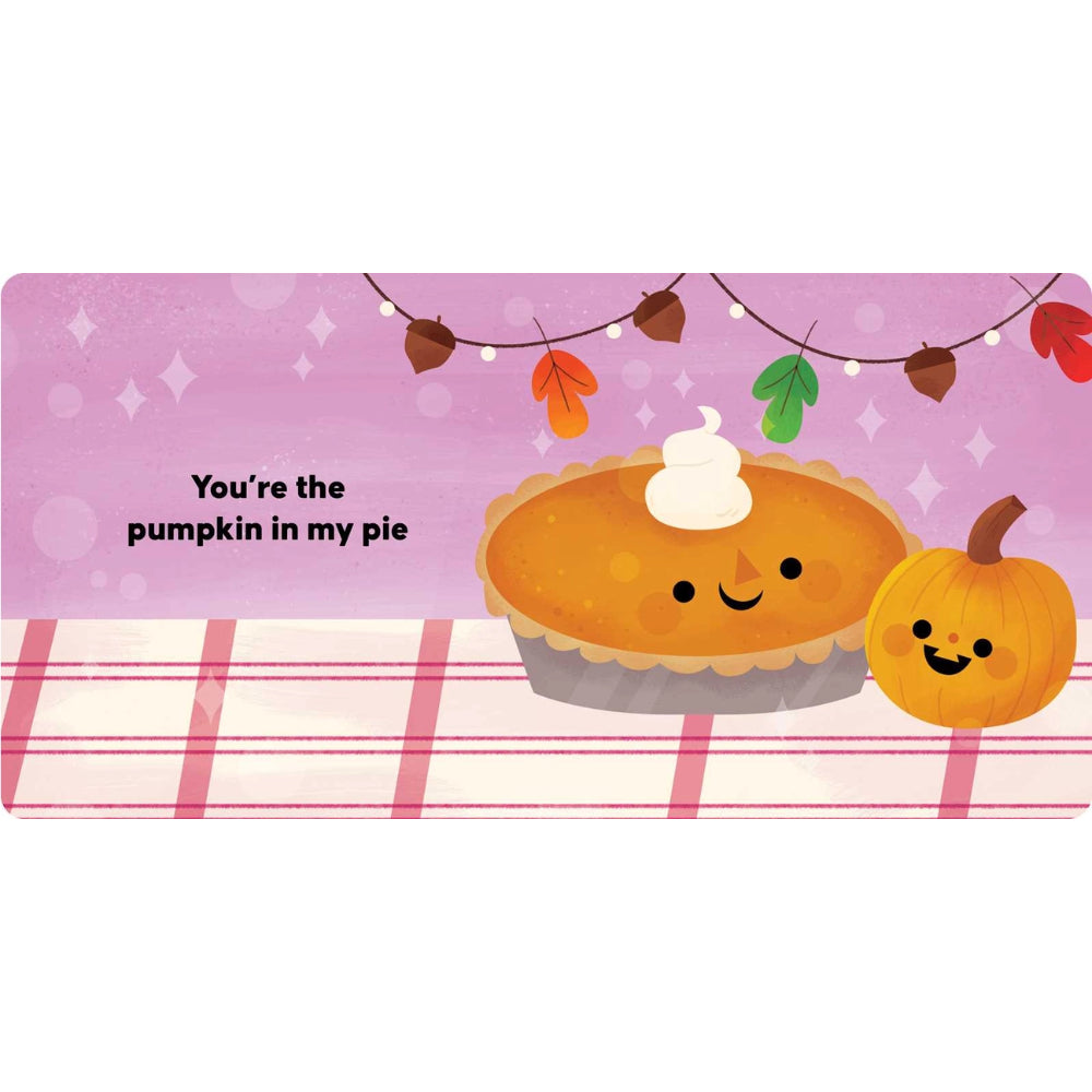 A rectangular printed graphic with a pink background and the phrase 'You're the pumpkin in my pie' in black text. It shows a smiling pumpkin pie with whipped cream and a small smiling pumpkin on a pink-and-white plaid surface, with fall leaves and string lights above.