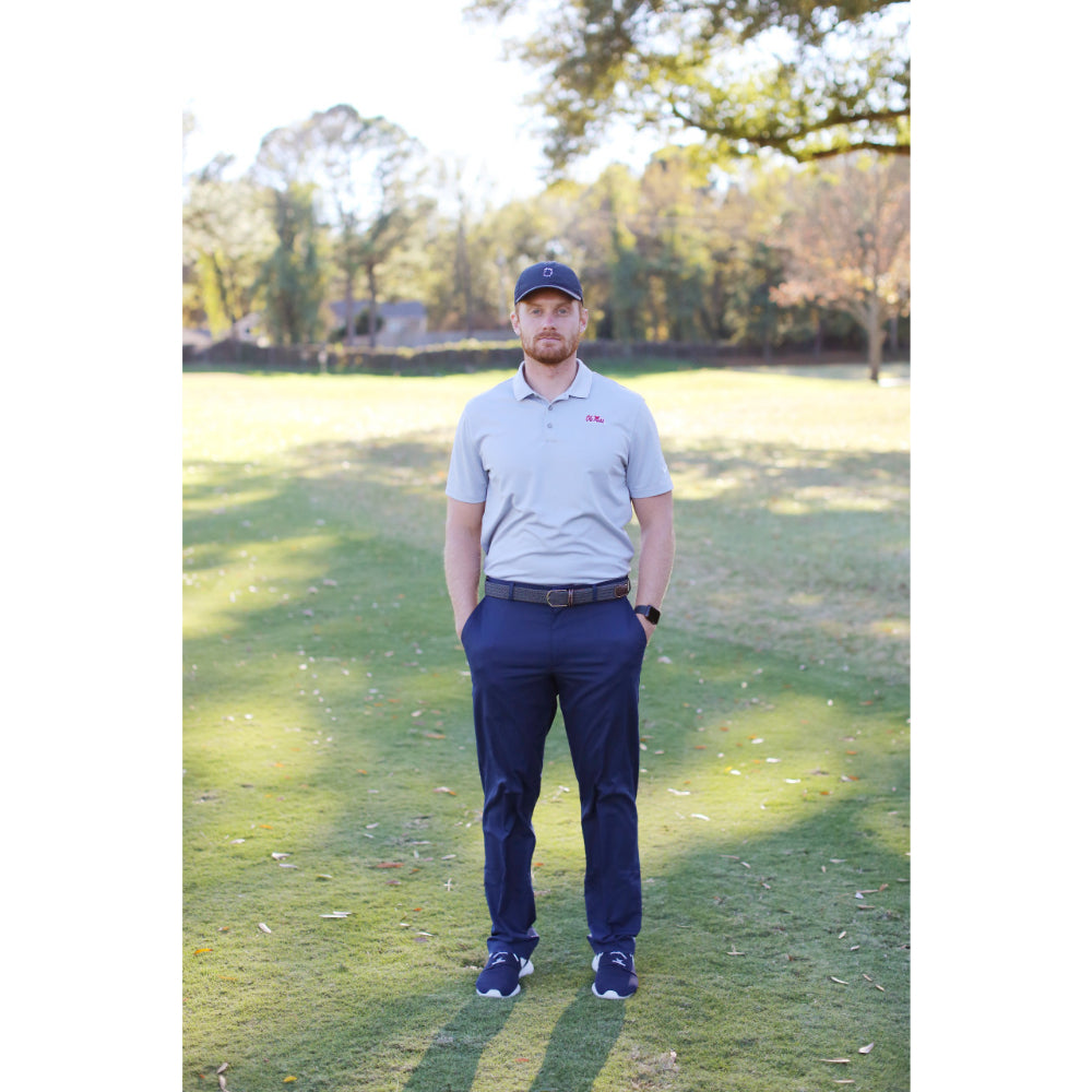 person wearing woven belt outdoors on golf course.  