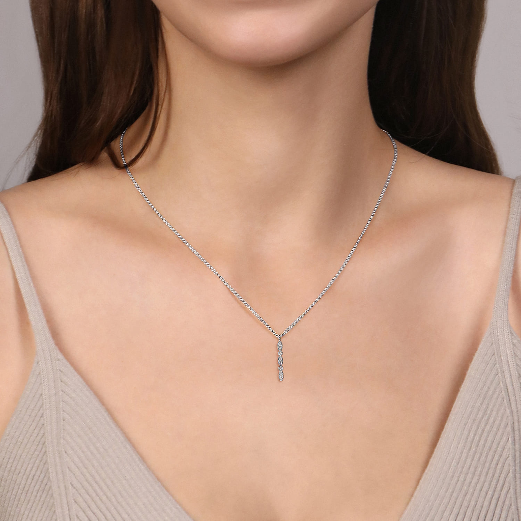 Necklace with a pendant worn by a model against a neutral background