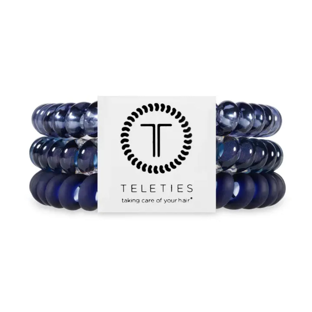 Set of blue hair ties with a Teleties branded card on a white background