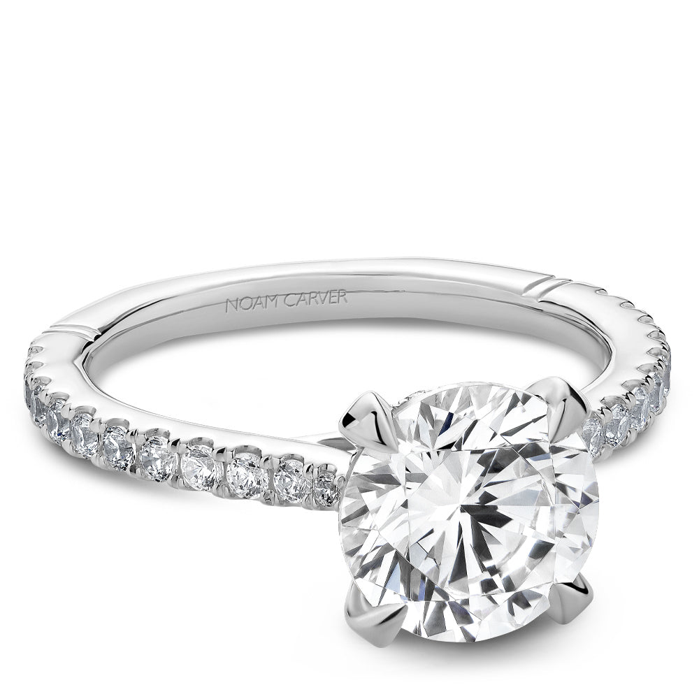 Diamond ring with 'Noam Carver' engraving on a white background