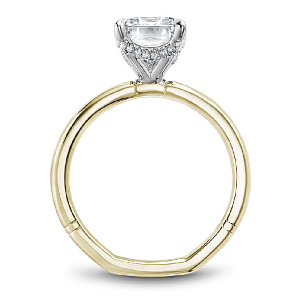 Gold Noam Carver ring with an emerald diamond center on a white background